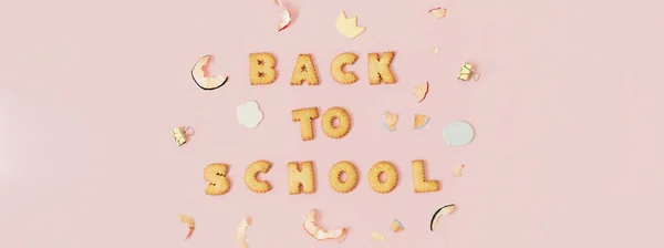 五颜六色的背景与文字回学校的饼干在粉红色的粉彩背景 — 图库照片
