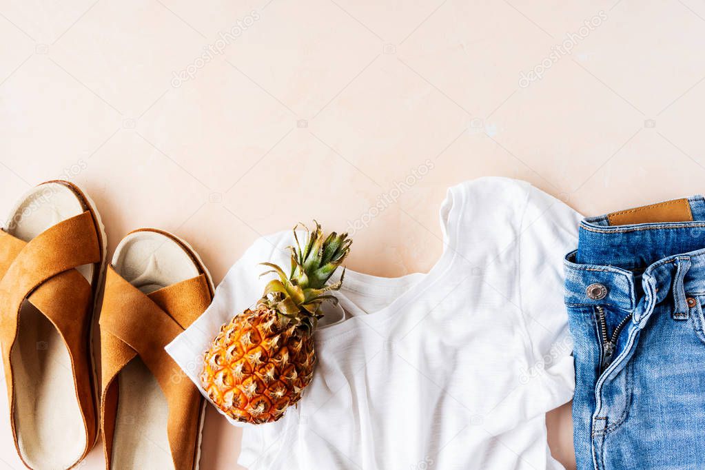 White t-shirt, denim shorts and trendy leather sandals with pineapple on pink pastel background
