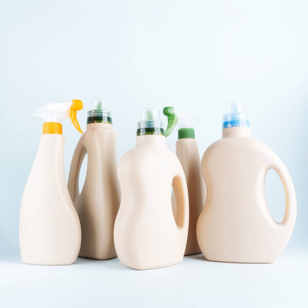 Бутылки моющих средств на голубом пастельном фоне
 