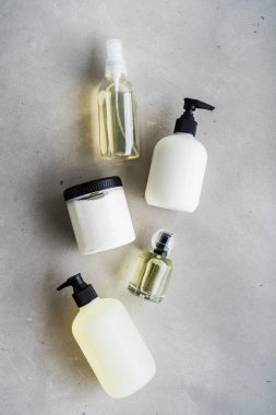 Gri beton arka plan üzerinde şişe kozmetik seti üst görünümü
