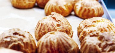 Parşömen üzerinde taze pişmiş profiteroles yakın görünümü