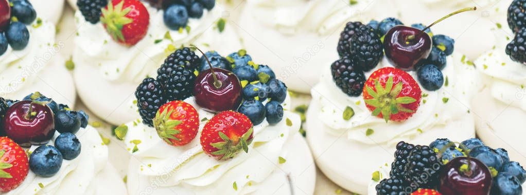 Close view of Pavlov cakes with fresh berries and whipped cream