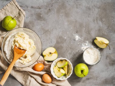 Gri beton arka planda un, yumurta ve kesilmiş elmaların üst görünümü