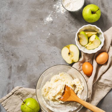 Gri beton arka planda un, yumurta ve kesilmiş elmaların üst görünümü