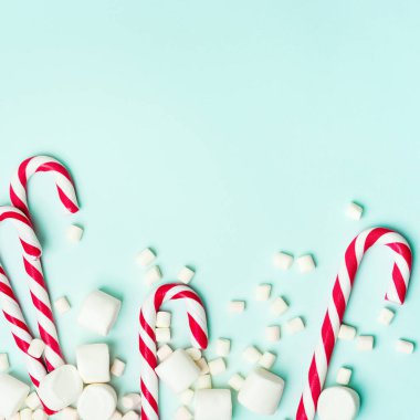 Kırmızı şeker bastonlar ve turkuaz arka planda Marshmallow yığını