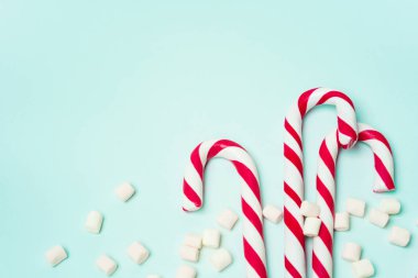 Kırmızı şeker bastonlar ve turkuaz arka planda Marshmallow yığını