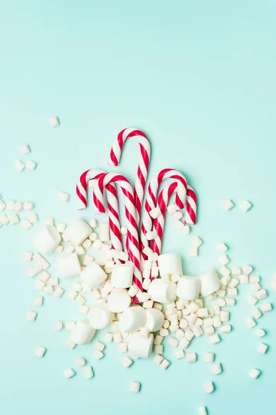 Kırmızı Şeker Bastonlar Turkuaz Arka Planda Marshmallow Yığını — Stok fotoğraf