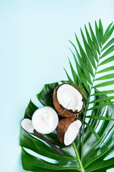 有机健康椰子奶油在罐子与新鲜的椰子在棕榈叶绿松石背景 — 图库照片