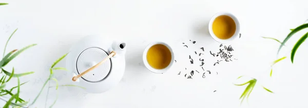 亚洲设置绿茶 杯子和茶壶在白色背景与绿叶 — 图库照片