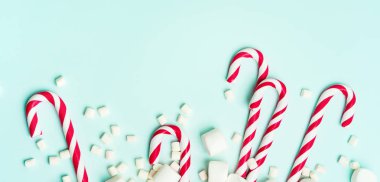 Kırmızı şeker bastonlar ve turkuaz arka planda Marshmallow yığını