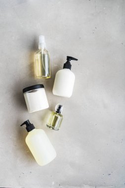 Gri beton arka plan üzerinde şişe kozmetik seti üst görünümü