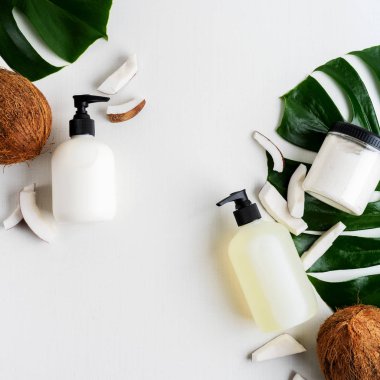 Yeşil yaprakları ve hindistan cevizi ile gri beton arka plan üzerinde ambalaj için şişe Kozmetik seti 