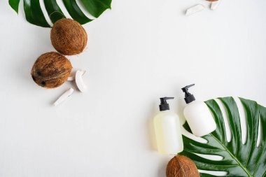 Yeşil yaprakları ve hindistan cevizi ile gri beton arka plan üzerinde ambalaj için şişe Kozmetik seti 