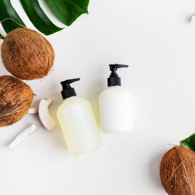 Yeşil yaprakları ve hindistan cevizi ile gri beton arka plan üzerinde ambalaj için şişe Kozmetik seti 