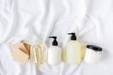 Beyaz pamuk havlu arka plan üzerinde kozmetik şişeüst görünümü