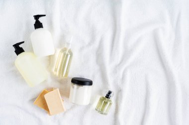 Beyaz pamuk havlu arka plan üzerinde kozmetik şişeüst görünümü