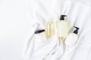 Beyaz pamuk havlu arka plan üzerinde kozmetik şişeüst görünümü