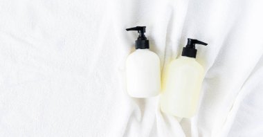 Beyaz arka plan üzerinde beyaz kabarık havlu üzerinde yatan şişe çift