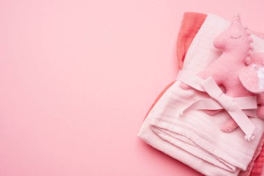 Muslin Bebek Bezi pembe arka plan üzerinde tek boynuzlu at oyuncak ile bezi