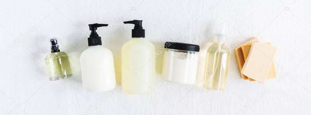 Top view of cosmetic bottles on white cotton towel background