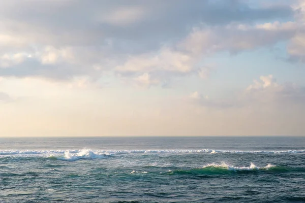 Okyanus üzerinde şafağın narin renkleri. Güzel pastel renklere sahip tropikal denizin minimalist bir görüntüsü. Tasarım ve ağ kurmak için