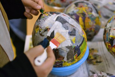 Çocuk elinde bir tabak kağıt, ışıma, balon ve fırça yapıyoruz.