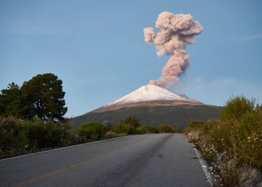 Column of smoke on Popocatepetl volcano seen from the street Ruta de Evacuacion, puebla, Mexico clipart