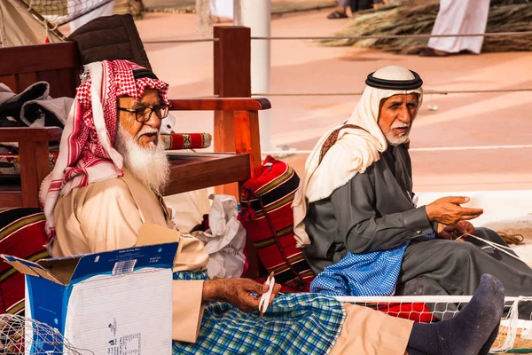 Geleneksel giyimli iki yaşlı adam balık ağı ördü. Janadriyah Festivali'nde Bae expo