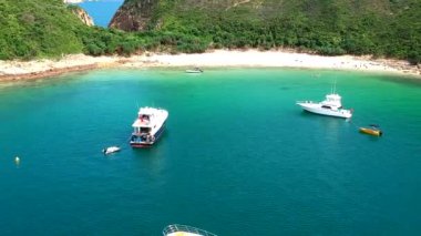 Bluff Island, Hong Kong yakınlarındaki koyda demirli yatlar ve yüzme insanların bir drone görünümü