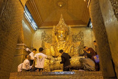 Mandalay, Myanmar - 25 Aralık 2011: Mahamuni Buda heykeline altın yapraklar takan erkek dindarlar