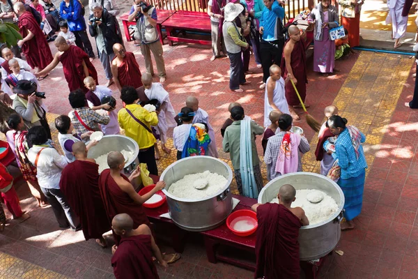 マンダレーのマハーガンダヨン修道院で世界最大の仏教僧ランチの間に食べ物を配布観光客 — ストック写真