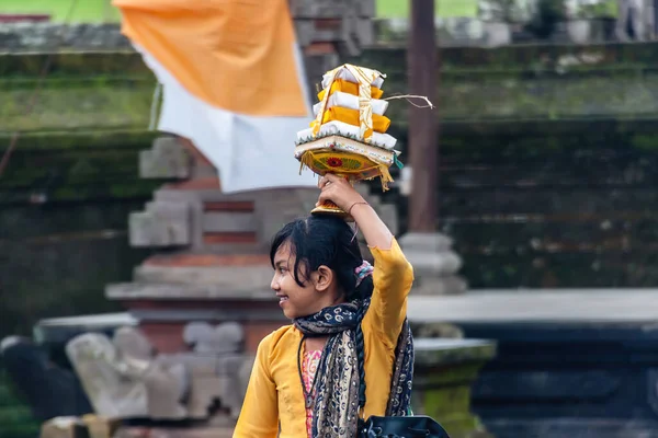 伝統的な祭りの間に頭の上に食べ物を運ぶバリの女の子 — ストック写真
