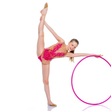 Kız jimnastikçi bir egzersiz bir çember ile gerçekleştirir.