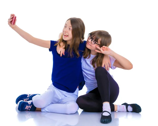 Two girls make a self-portrait on a smartphone. — Stock Photo, Image