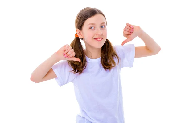 彼女の空の白い t シャツを指す小さな学校の女の子. — ストック写真