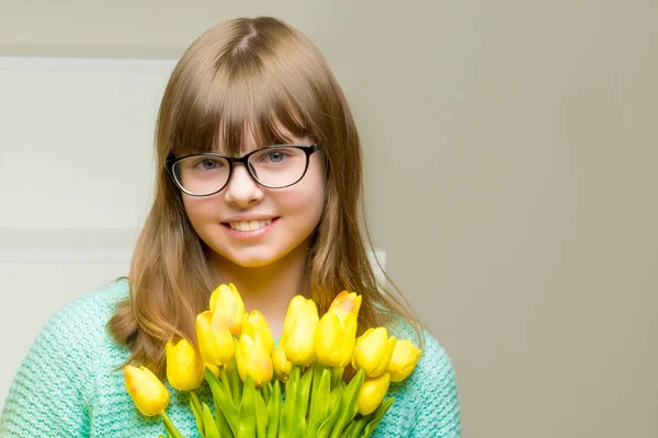 Маленька дівчинка з букетом тюльпанів сидить на сходах . — стокове фото