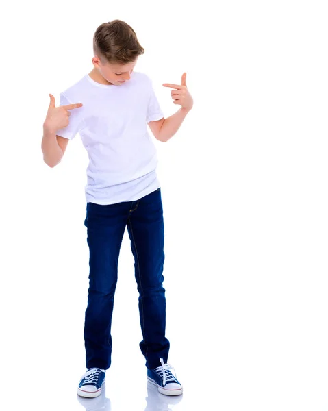 Um menino da escola aponta para sua camiseta branca . — Fotografia de Stock