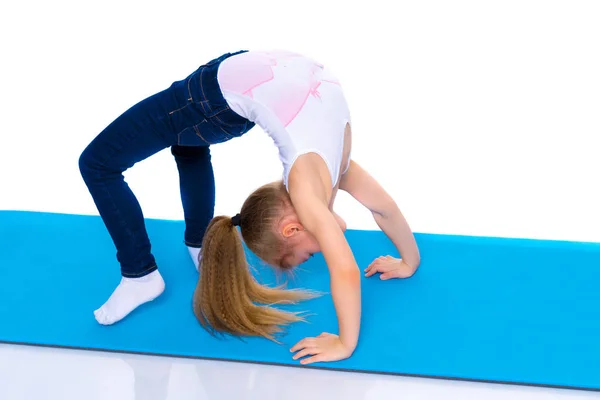 The little gymnast performs a bridge. — Stock Photo, Image