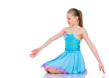 Küçük jimnastikçi yerde akrobatik bir şey yapıyor..