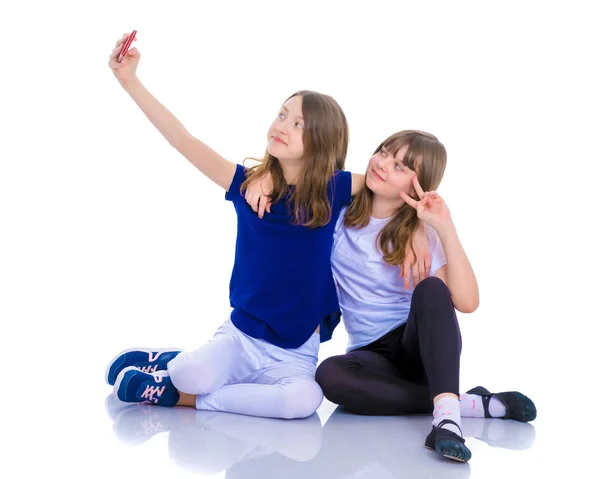Twee meisjes maken een zelfportret op een smartphone. — Stockfoto