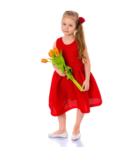 Klein meisje met een boeket tulpen. — Stockfoto