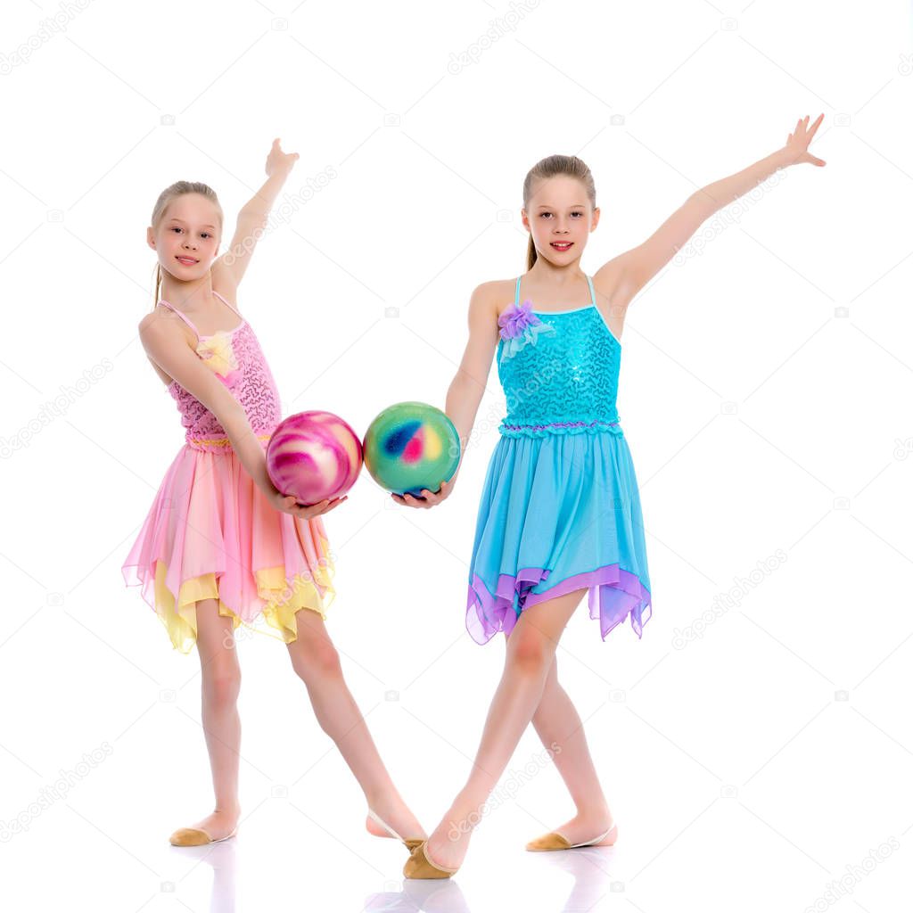 Girls gymnasts perform exercises with the ball.
