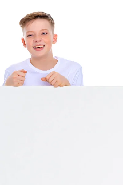 A boy of school age near a white advertising banner. — Stock Photo, Image