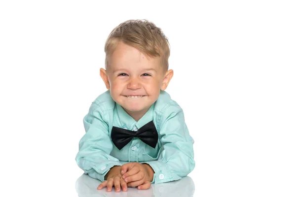 Een kleine jongen is liggend op de vloer in de studio. — Stockfoto