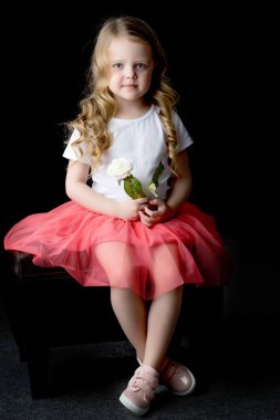 Onun elinde bir çiçek ile küçük kız. 