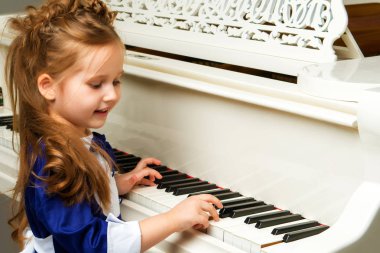 Kız beyaz piyanonun başında..