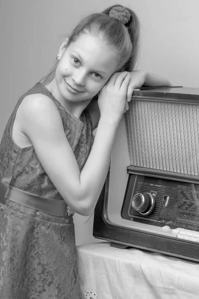 The girl is at the old radio.