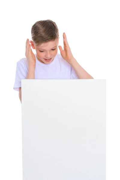 Хлопчик шкільного віку біля білого рекламного банера . — стокове фото