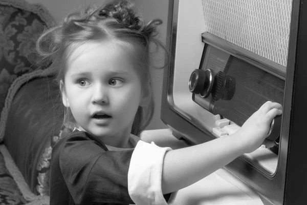 Flickan är på den gamla radion. — Stockfoto