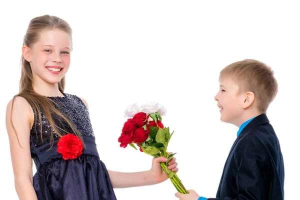 A little boy gives the girl flowers. — Stock Photo, Image